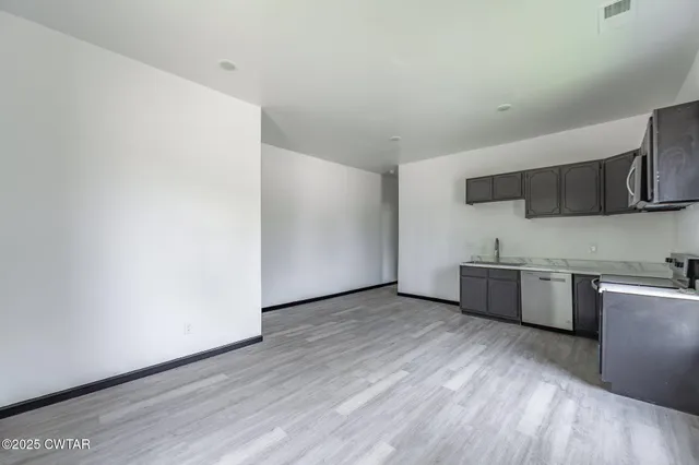 a kitchen with stainless steel appliances a microwave and sink
