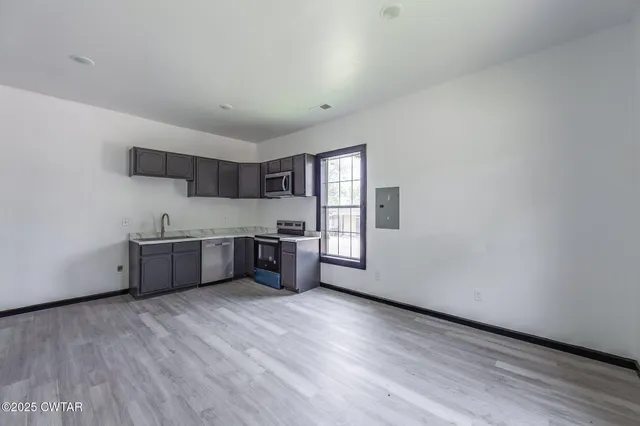 a kitchen with stainless steel appliances a sink and cabinets