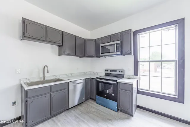 a kitchen with stainless steel appliances granite countertop a sink stove and microwave