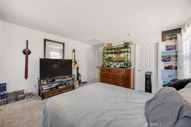 a bedroom with a bed and a flat screen tv