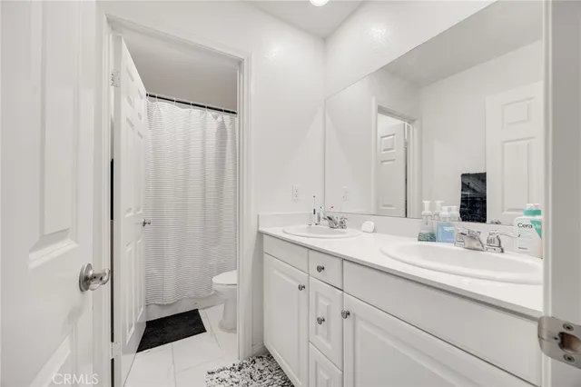 a bathroom with a double vanity sink toilet and shower