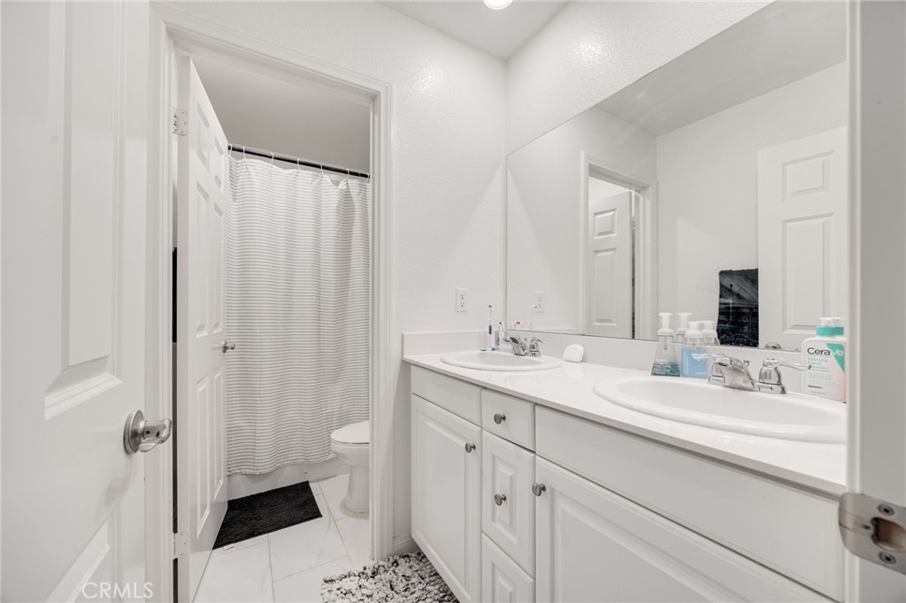 21192 Telegraph Road Riverside, CA 92507 - Photo 14 of 35 a bathroom with a double vanity sink toilet and shower