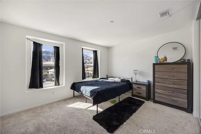 a bedroom with a bed window and dresser