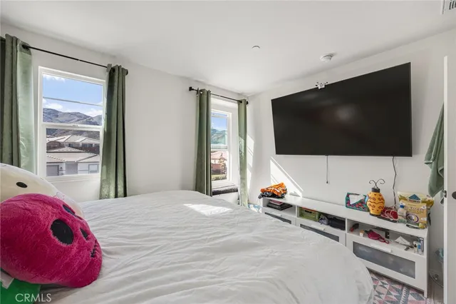 a bedroom with furniture and a flat screen tv