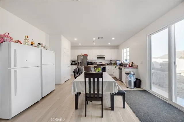 a view of a dining room with furniture a kitchen view and a refrigerator