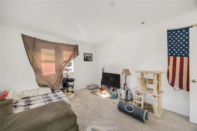 a bedroom with bed and a flat tv screen on dresser