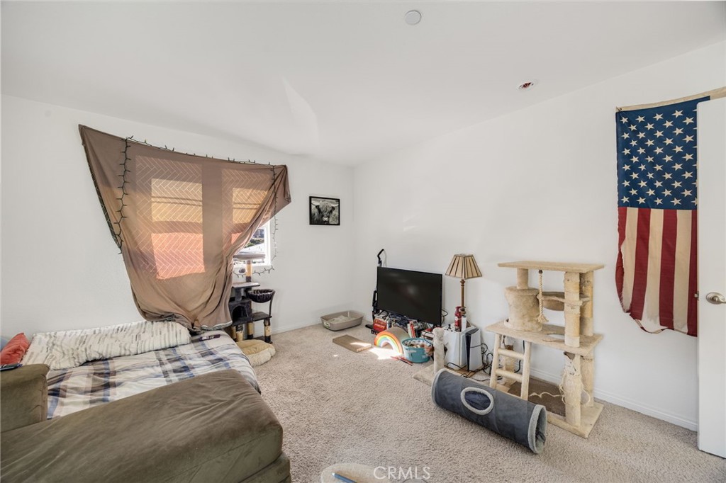 21192 Telegraph Road Riverside, CA 92507 - Photo 22 of 35 a bedroom with bed and a flat tv screen on dresser