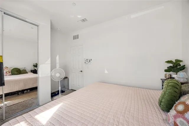 a bedroom with a bed and a potted plant