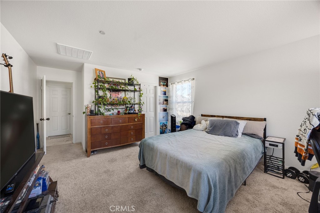 21192 Telegraph Road Riverside, CA 92507 - Photo 10 of 35 a bedroom with a bed and a flat tv screen on dresser