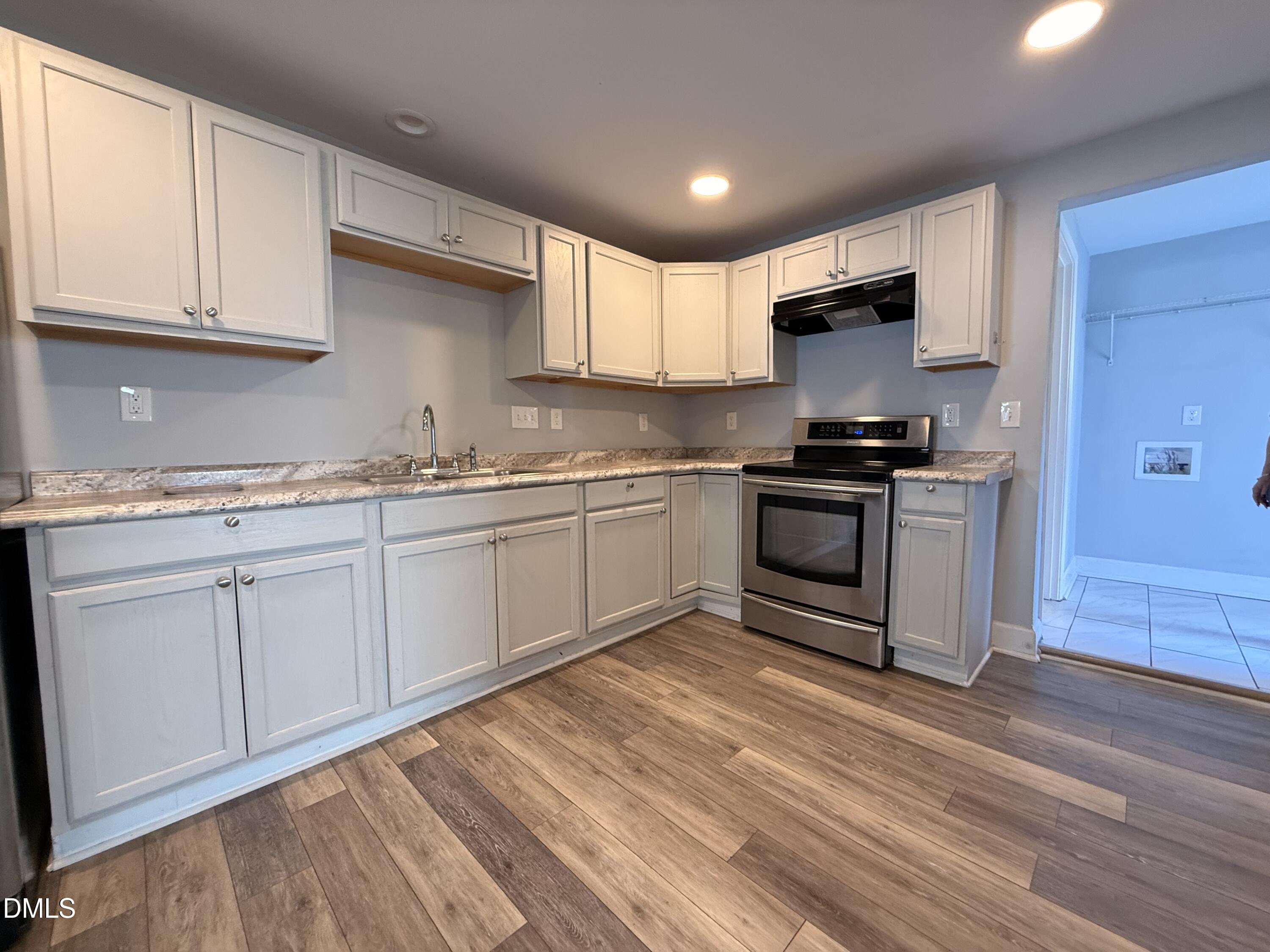307 Broad Street Roxboro, NC 27573 - Photo 8 of 16 a kitchen with stainless steel appliances granite countertop a sink a stove a refrigerator and cabinets