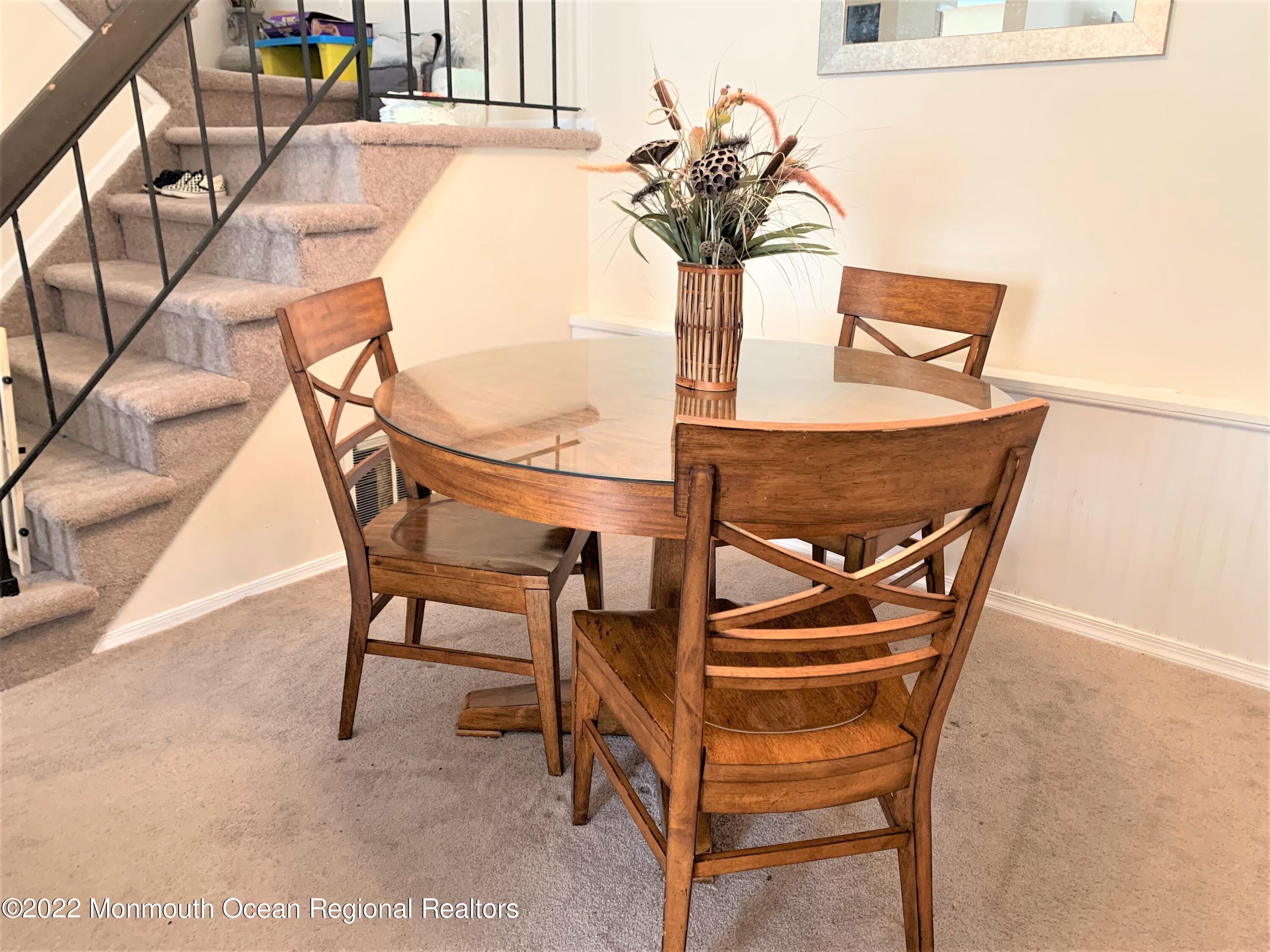 18 Sutton Drive, Unit 301 Brick, NJ 08724 - Photo 5 of 16 a glass vase with flowers on a table and chairs