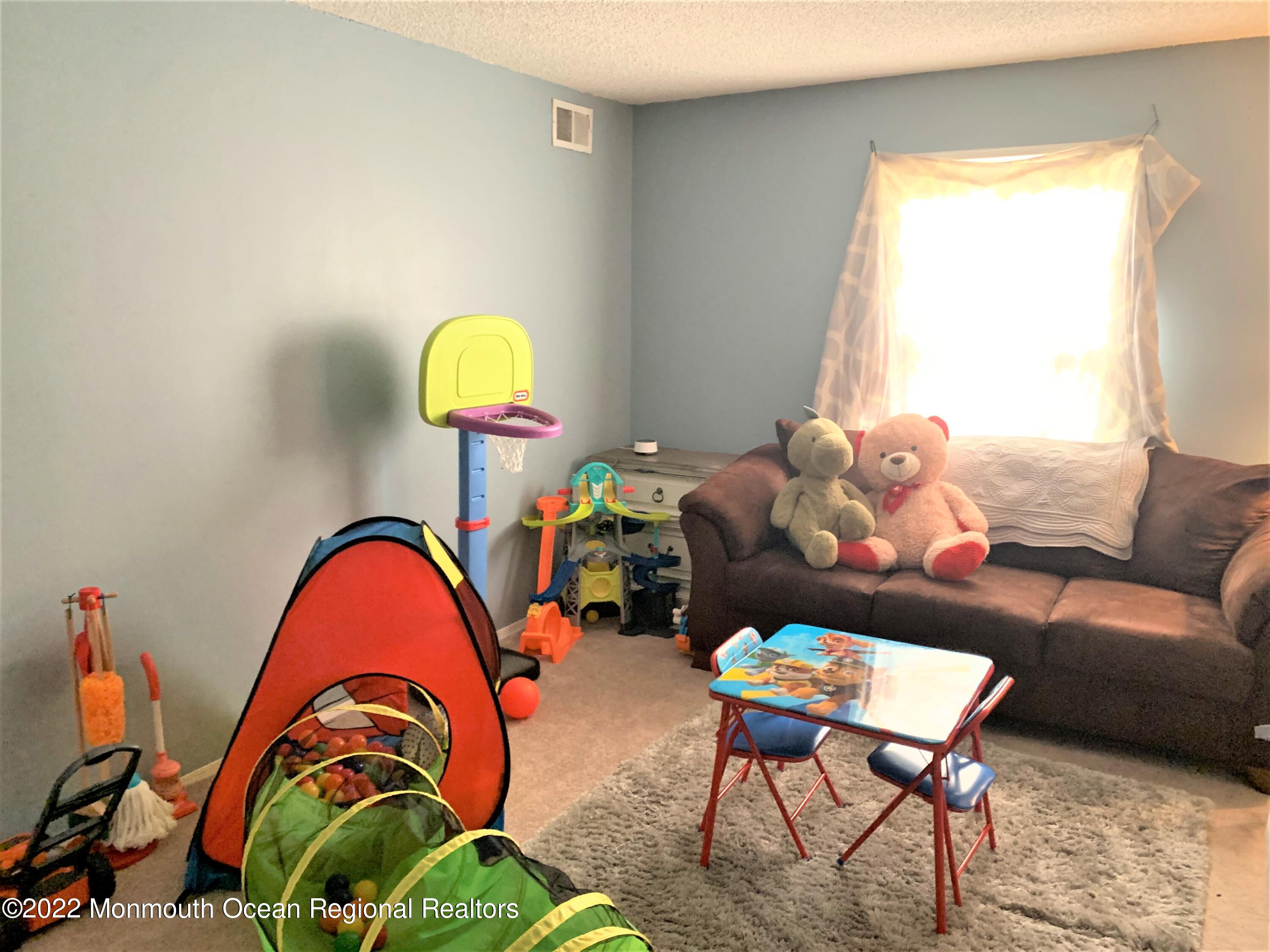 18 Sutton Drive, Unit 301 Brick, NJ 08724 - Photo 10 of 16 a living room with a couch and a potted plant