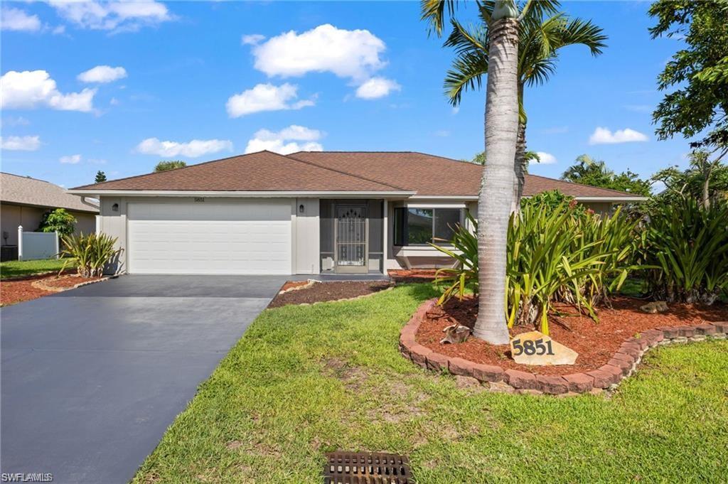 Ranch-style home featuring a garage and a front lawn
