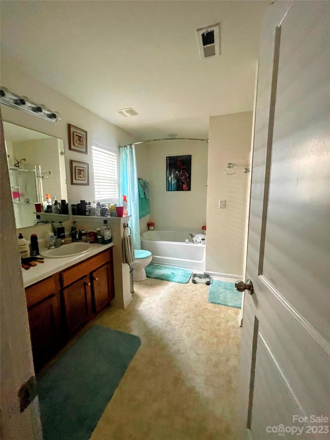 1002 Mearn Road, Unit 98 Charlotte, NC 28216 - Photo 3 of 9 a spacious bathroom with a double vanity sink a mirror and a bathtub
