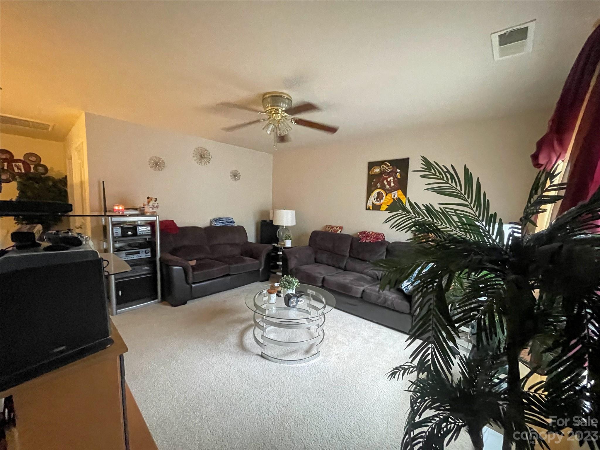 1002 Mearn Road, Unit 98 Charlotte, NC 28216 - Photo 4 of 9 a living room with furniture a flat screen tv and kitchen view