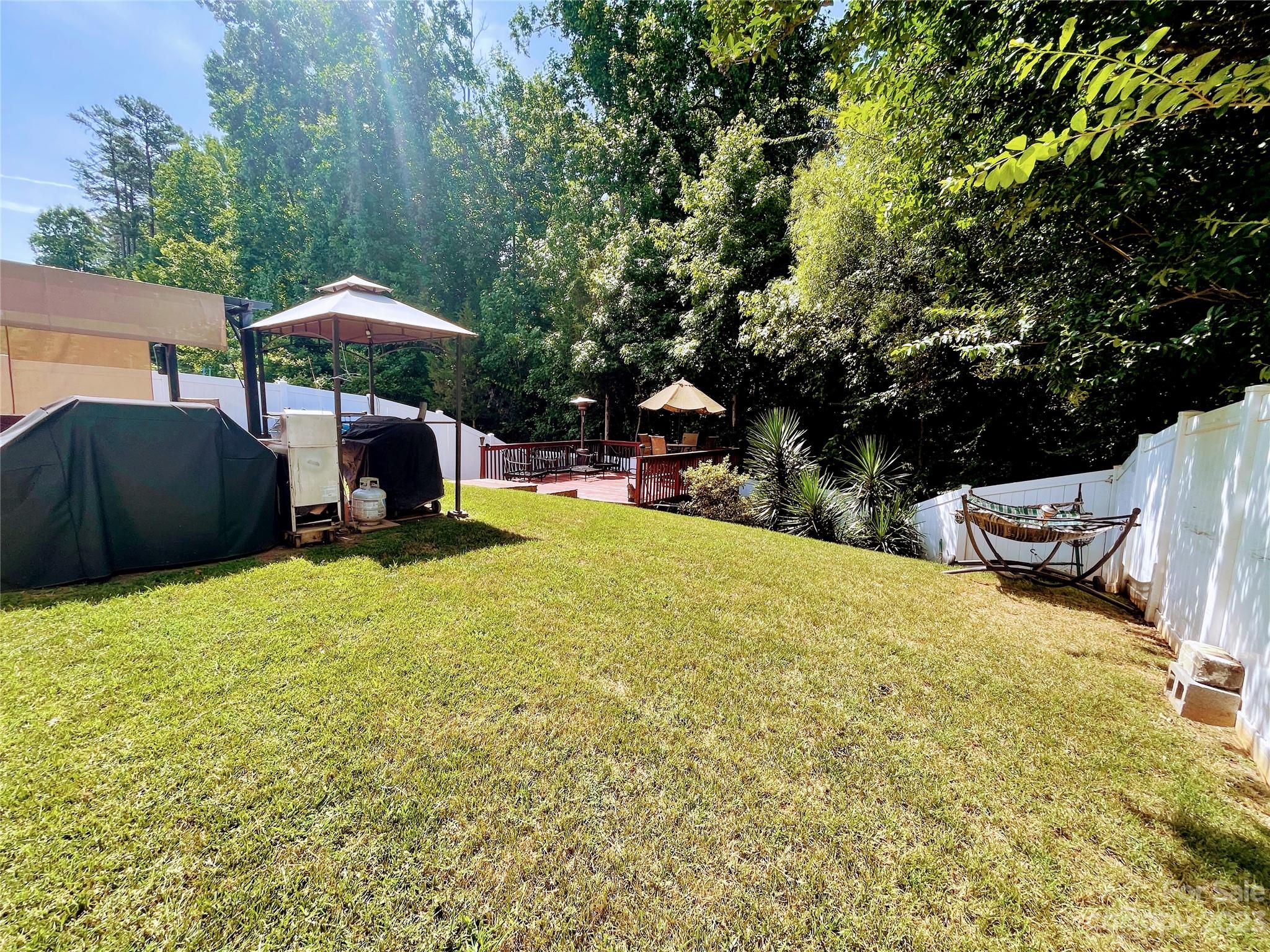 1002 Mearn Road, Unit 98 Charlotte, NC 28216 - Photo 8 of 9 a backyard of a house with table and chairs under an umbrella