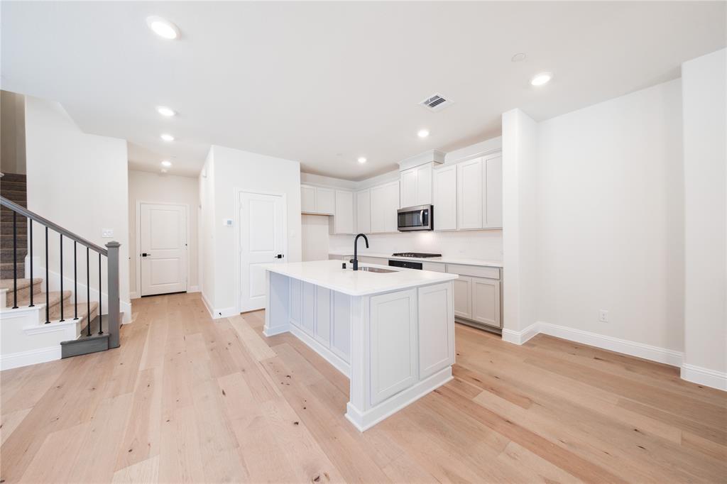 a view of kitchen with wooden floor and electronic appliances