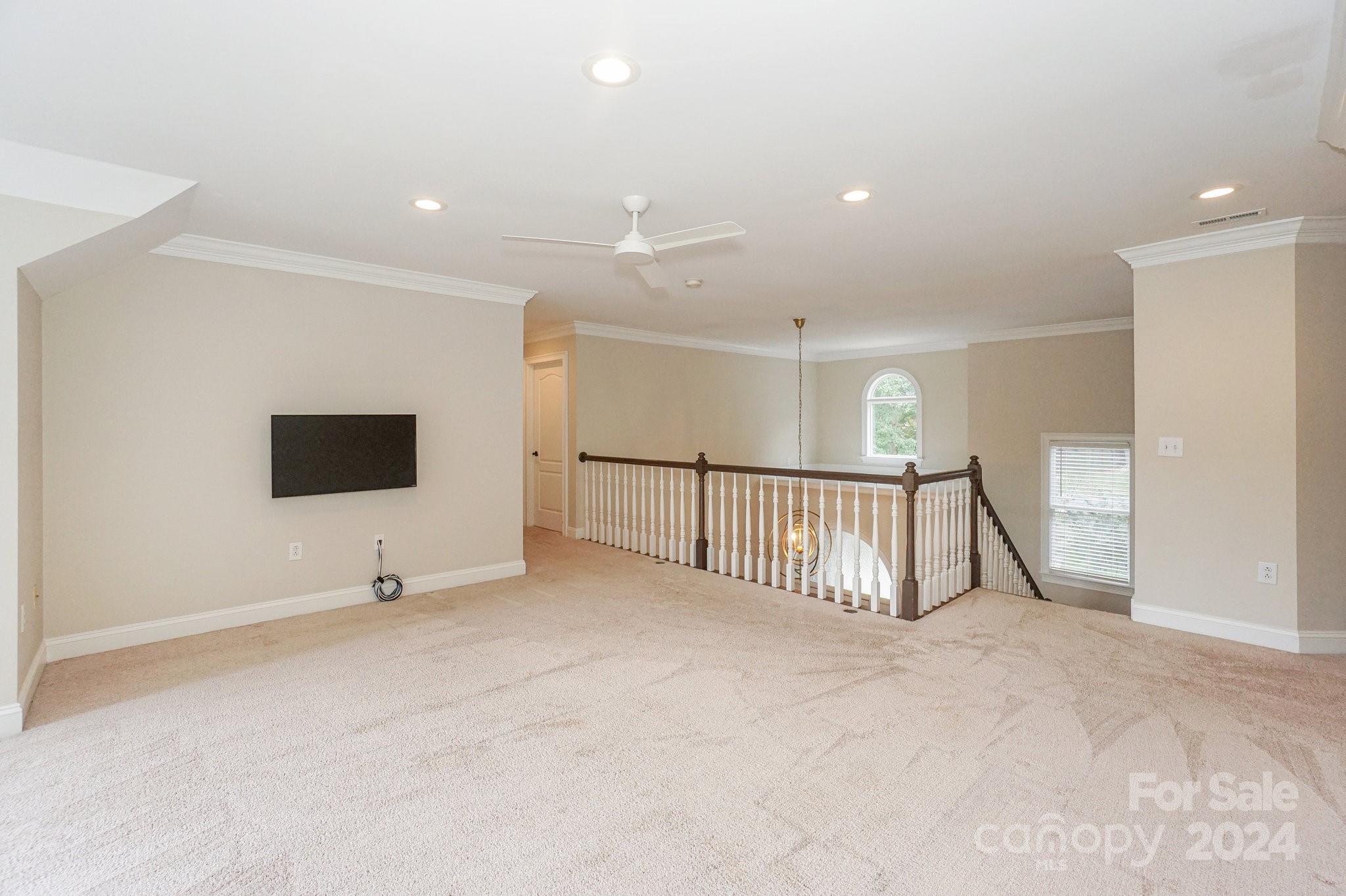 21910 Satilla Drive Cornelius, NC 28031 - Photo 27 of 47 an empty room with large windows and a ceiling fan