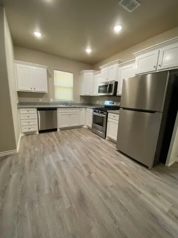 a kitchen with stainless steel appliances a refrigerator sink and microwave