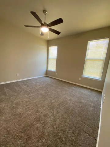 an empty room with a window and a fan