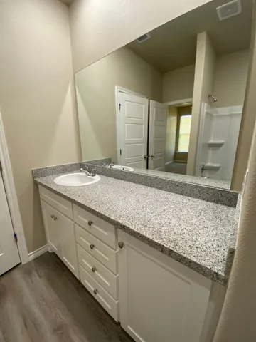 a bathroom with a granite countertop sink and a mirror