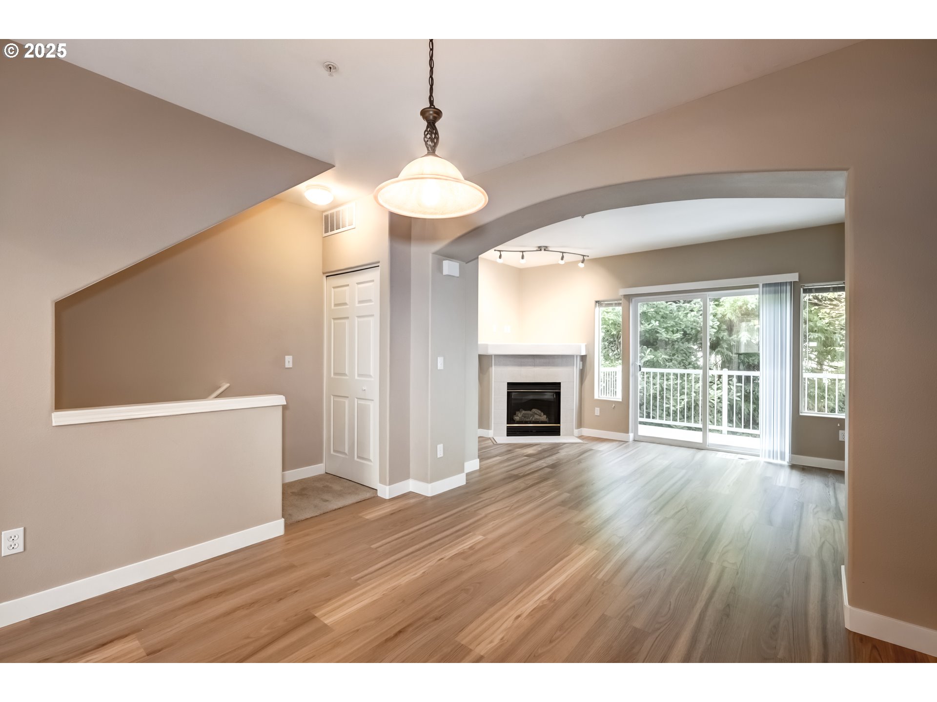 16080 Southwest Audubon Street, Unit 103 Beaverton, OR 97003 - Photo 6 of 24 a view of empty room with wooden floor and fireplace