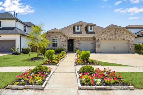 a front view of a house with a yard and flowers