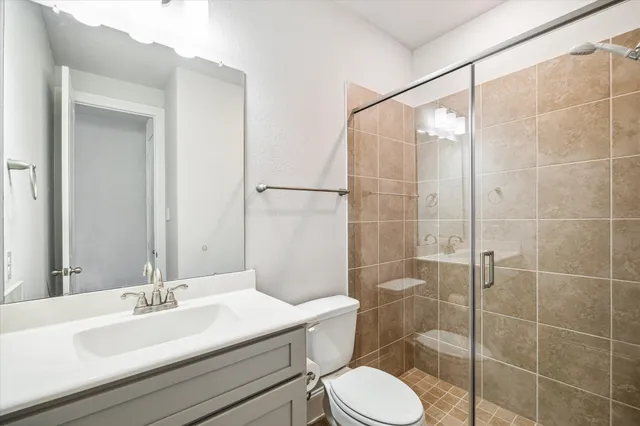 a bathroom with a sink a toilet and shower