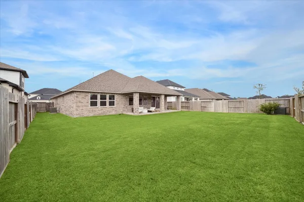 a view of a big house with a big yard and large trees
