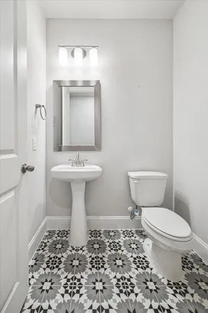 a bathroom with a sink toilet and a mirror