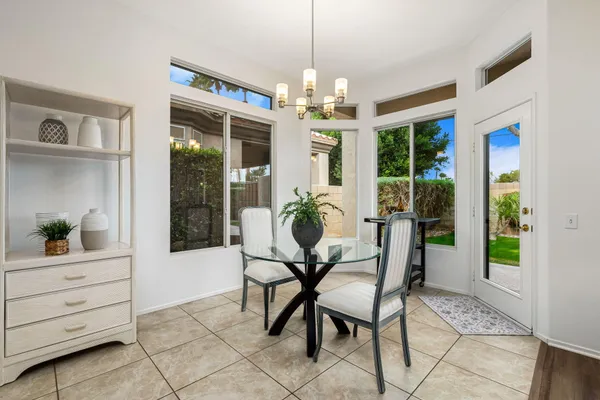 a dining room with furniture a chandelier and window