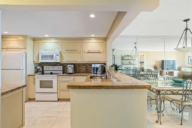 a kitchen with kitchen island a counter top space a sink stainless steel appliances and cabinets