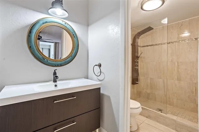 a bathroom with a sink a toilet and shower