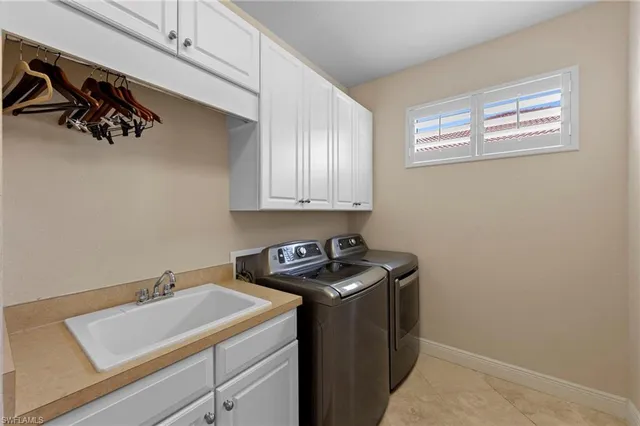 a utility room with sink dryer and washer