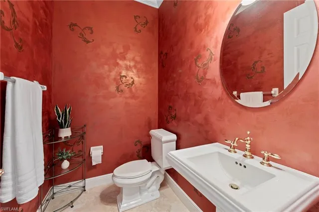 a bathroom with a sink mirror and toilet