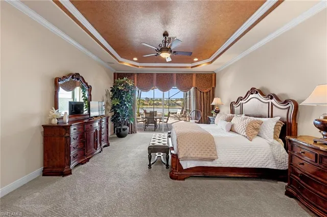 a spacious bedroom with a bed mirror on desk and a window