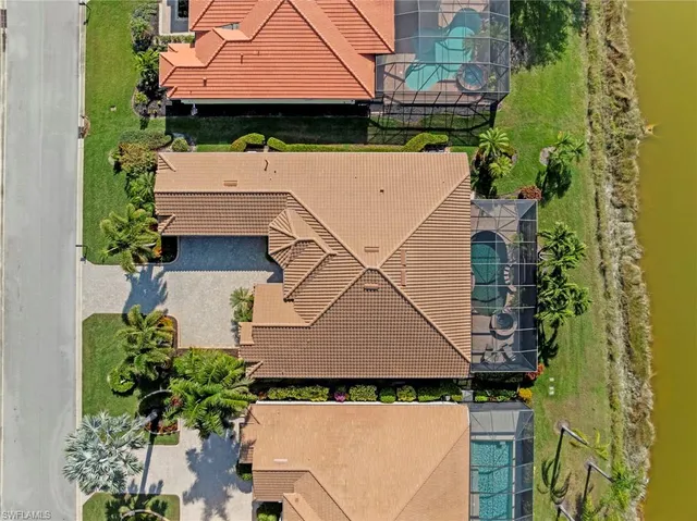 an aerial view of residential houses with outdoor space and lake view