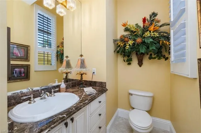 a bathroom with a granite countertop sink and a toilet