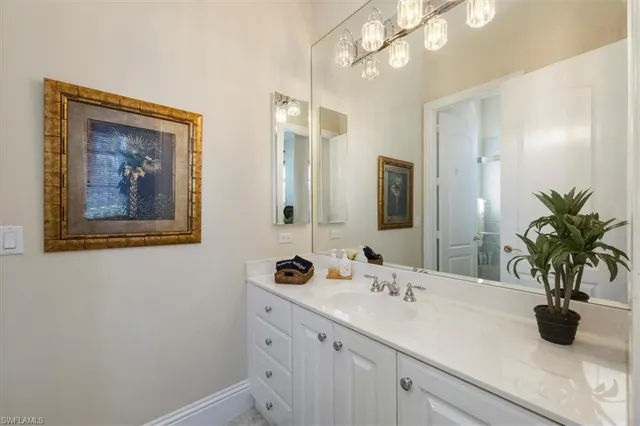 a bathroom with a sink a large mirror and vanity