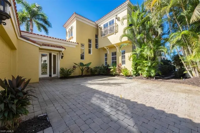 a view of a white house with a yard and plants
