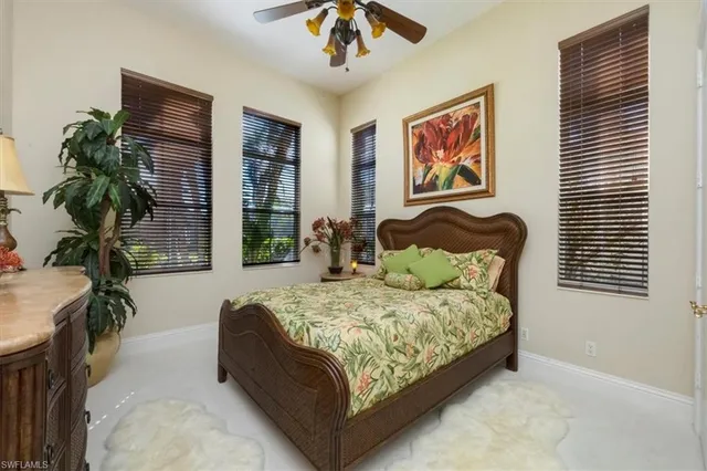 a bed sitting in a bedroom next to a window and a chandelier