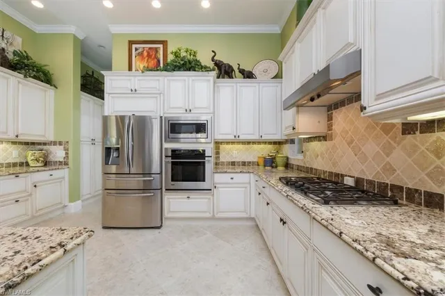 a kitchen with stainless steel appliances granite countertop a refrigerator and a stove