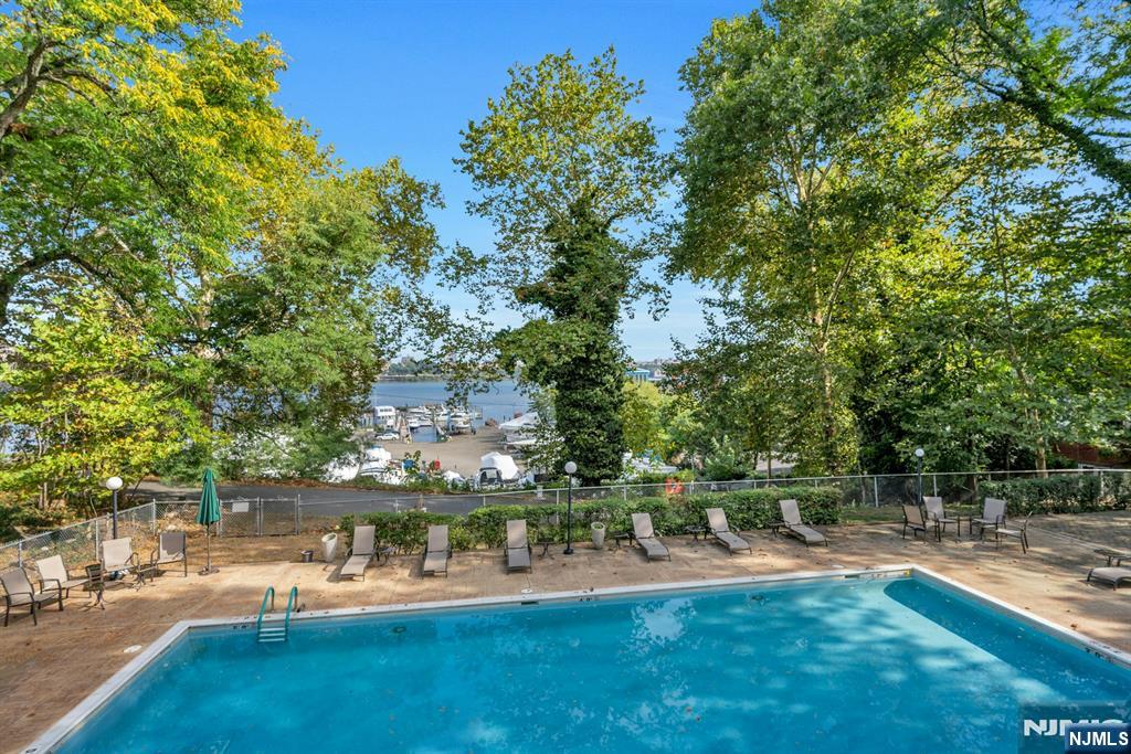 1375 River, Unit LG Edgewater, NJ 07020 - Photo 16 of 18 a view of backyard with swimming pool and seating space