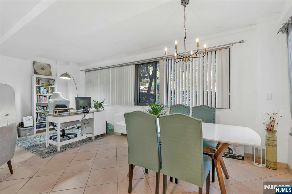 1375 River, Unit LG Edgewater, NJ 07020 - Photo 8 of 18 a living room with furniture a chandelier and a flat screen tv