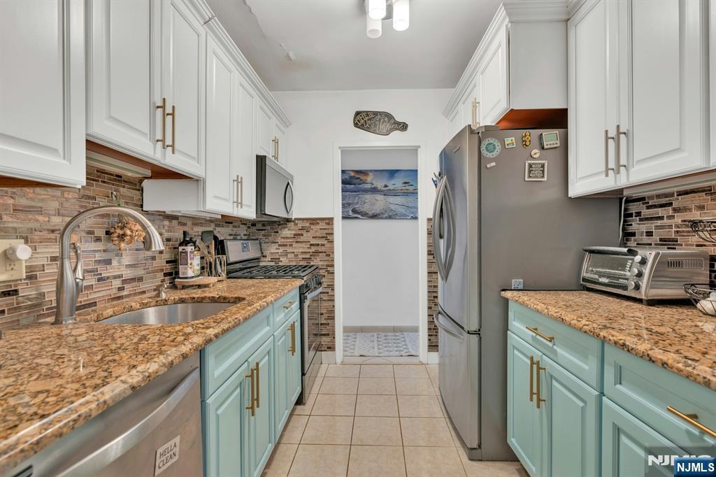 1375 River, Unit LG Edgewater, NJ 07020 - Photo 9 of 18 a kitchen with stainless steel appliances granite countertop a sink stove and refrigerator