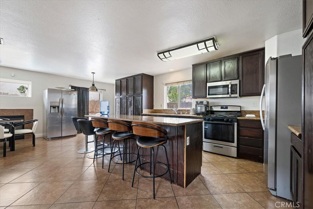 16220 Vía Ultimo Moreno Valley, CA 92551 - Photo 11 of 38 a kitchen with granite countertop a sink counter and chairs