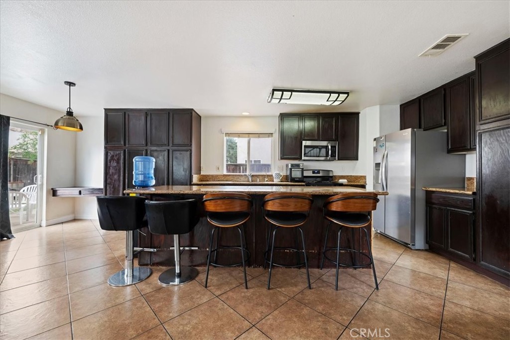 16220 Vía Ultimo Moreno Valley, CA 92551 - Photo 12 of 38 a kitchen with a dining table and chairs