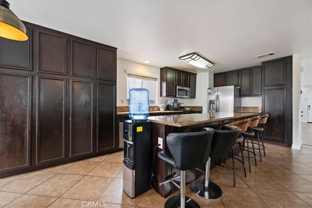 16220 Vía Ultimo Moreno Valley, CA 92551 - Photo 13 of 38 a kitchen with a table and chairs