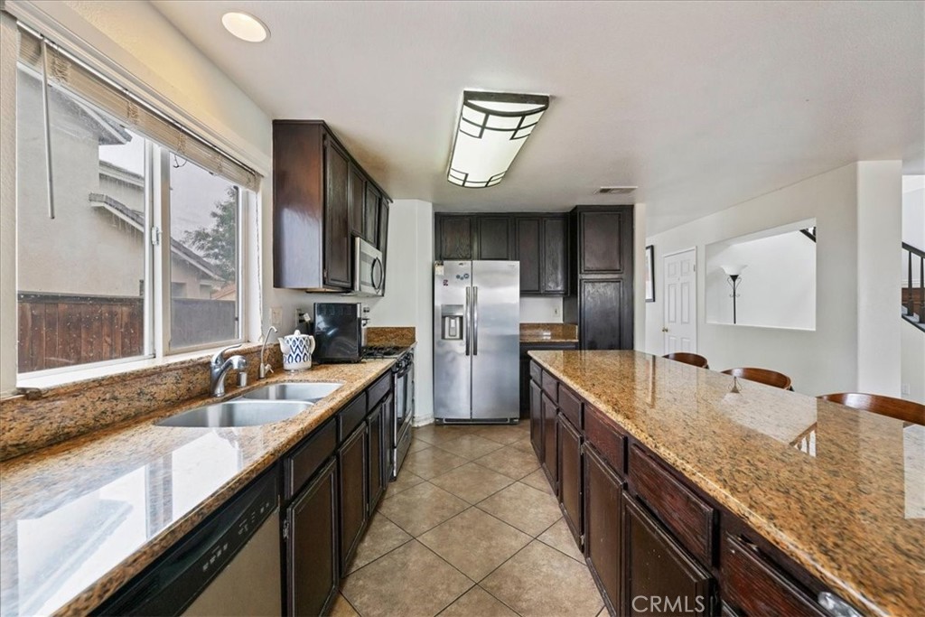 16220 Vía Ultimo Moreno Valley, CA 92551 - Photo 16 of 38 a large kitchen with granite countertop lots of counter space and sink