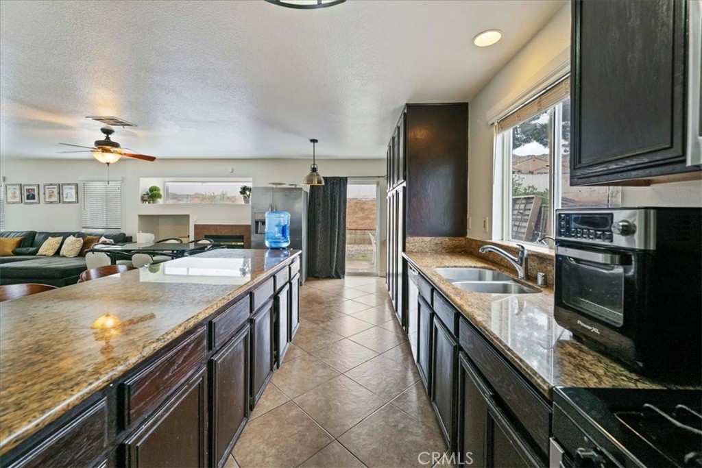16220 Vía Ultimo Moreno Valley, CA 92551 - Photo 17 of 38 a kitchen with stainless steel appliances granite countertop a stove a sink and a refrigerator